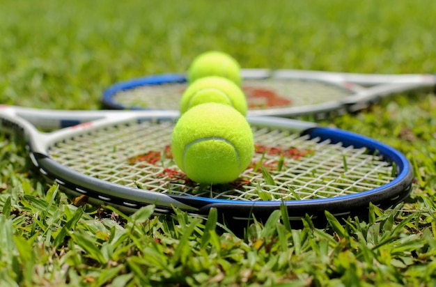 Tennisracket met ballen op het gras