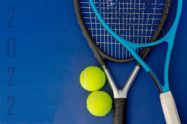 Tennisracket met tennisballen op blauwe ondergrond 2022