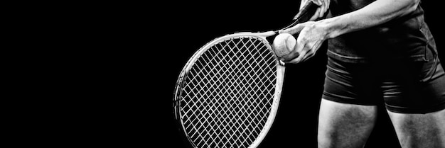 Tennisspeler met een racket klaar om te dienen op zwarte achtergrond