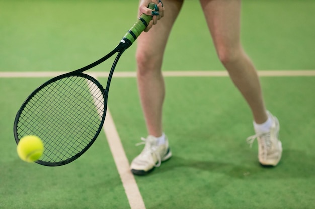 Tennisvrouwenspeler die training met racket en bal aan het hof speelt