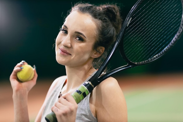 Tennisvrouwenspeler die training met racket en bal aan het hof speelt