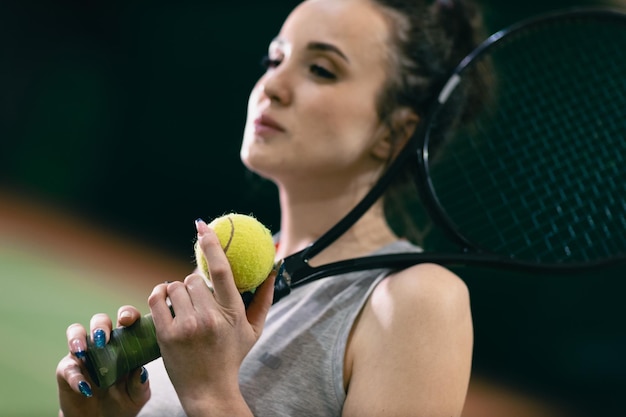 Tennisvrouwenspeler die training met racket en bal aan het hof speelt