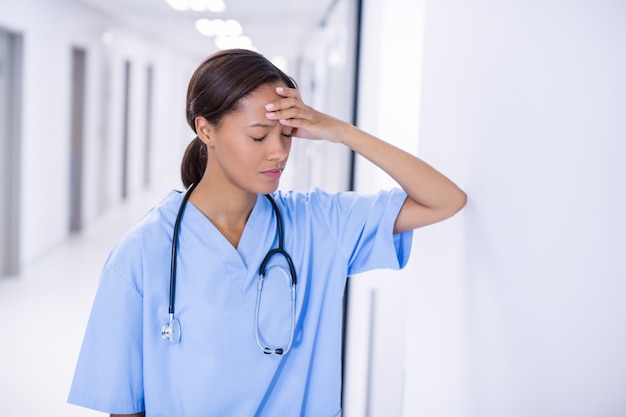 Photo tensed female doctor standing in corridor