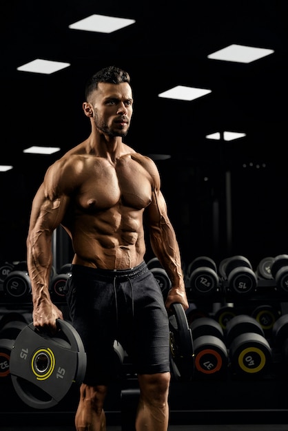 Tensed male bodybuilder holding weights.