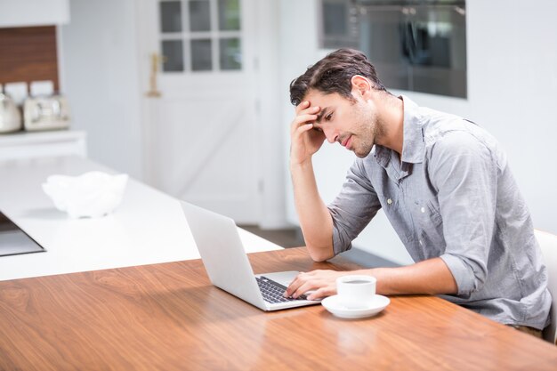 Tensed young man using laptop 