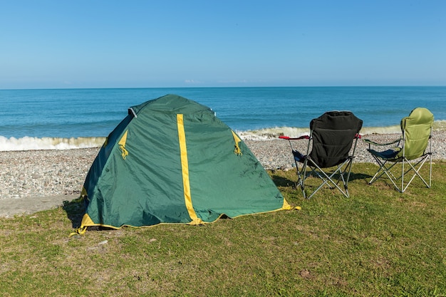 Tenda sulla spiaggia con due sedie in piedi sull'erba. tenda sulla spiaggia..viaggio in georgia