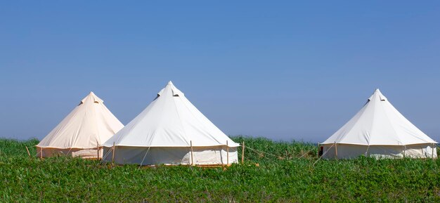 Tent on field against clear blue sky