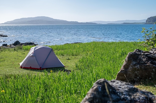 tent on field by sea against sky