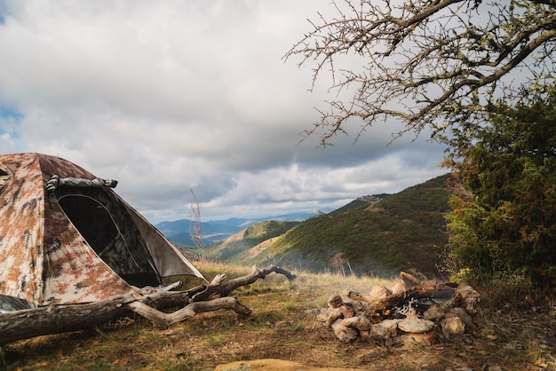 Tent in the mountains near a campfire on a hike in a tourist camp, activity, rest, relaxation, silence