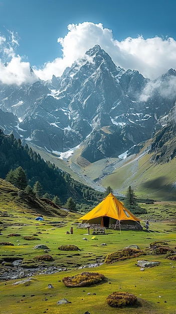 A tent in the mountains with snow capped mountains