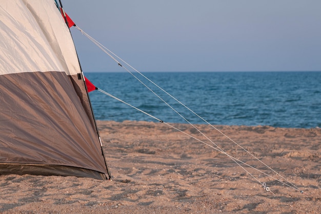 Tent op de zanderige kust tegen de achtergrond van de zee