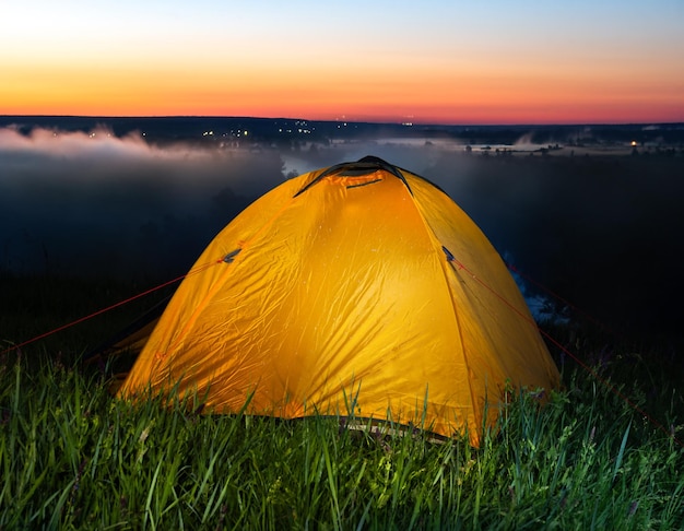 Tent in steppe near river at sunrise