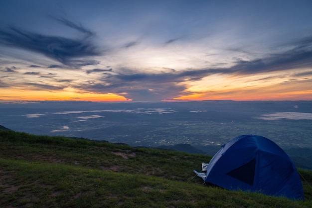 Tenten op de top van de heuvel in de buurt van de top van de bergketen bij zonsopgang.