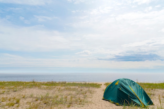 Tents on the sandy shore of the lake.