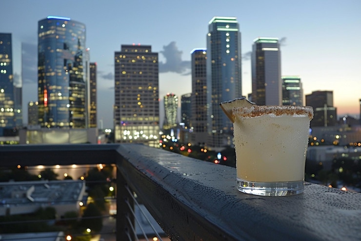 Photo a tequila cocktail with a backdrop of city lights