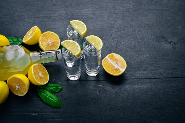 Текила свежий лимон и лимонный сок На деревянном фоне Вид сверху Свободное место для текста