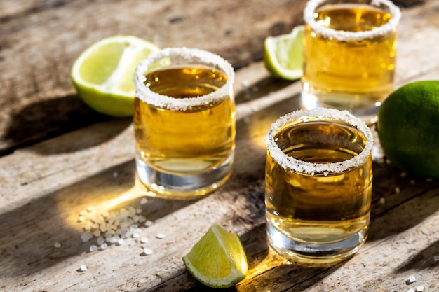 Photo tequila in a glass served with limes and salt mexican national drink