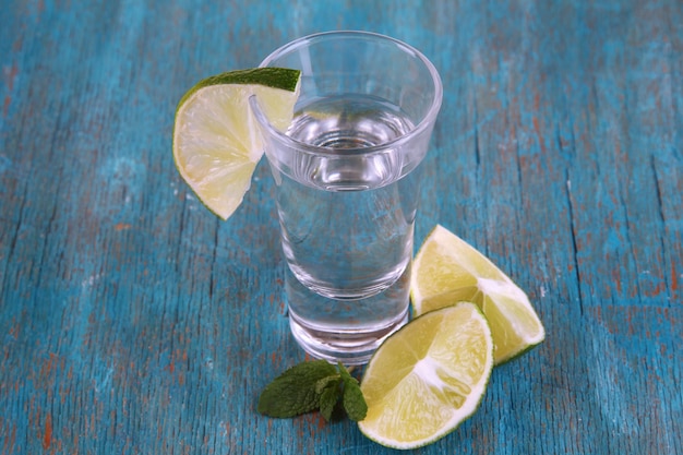 Tequila in glass on wooden table closeup