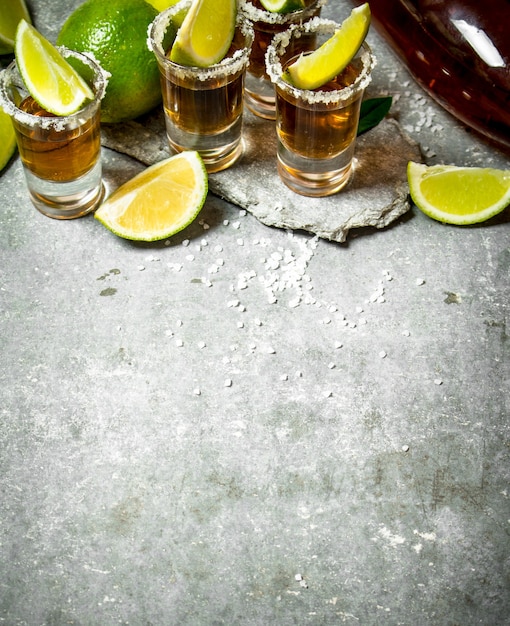 Tequila met zout en limoenplakken. Op de stenen tafel.