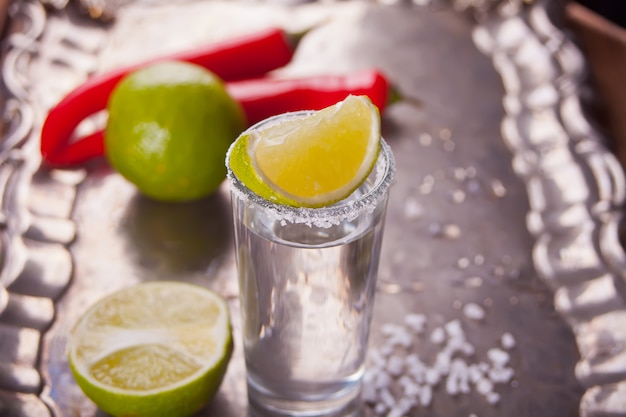 Tequila shot with lime and sea salt on tray