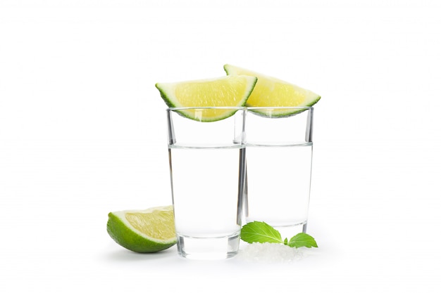 Tequila shots, lime, mint and salt isolated on white