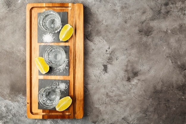 Tequila shots, limoenen en zout op een houten bord