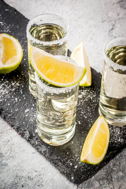 Tequila shots with lime and sea salt on grey stone table