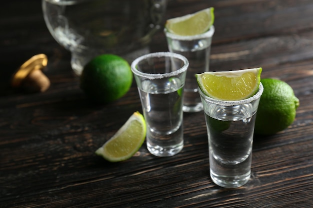 Tequila shots with lime slices and salt on table