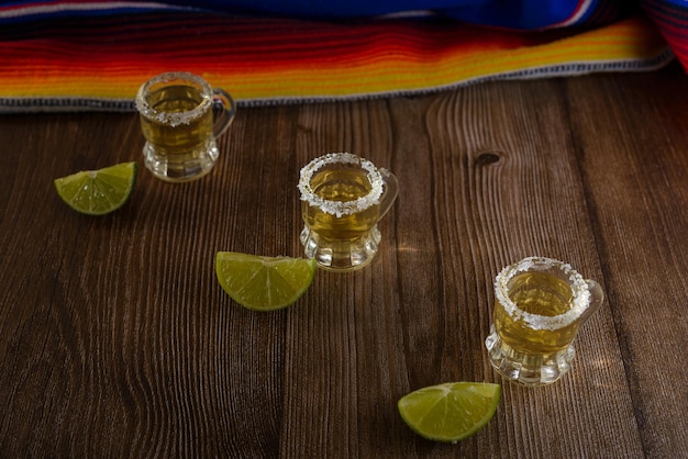 写真 バーテーブルに塩とライムを添えたテキーラショット テキーラと典型的なメキシコの要素のショット