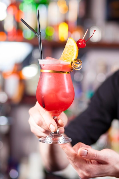 Tequila Sunrise cocktail in hands of bartender