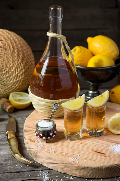 Tequila with a lemon and salt on a wooden table