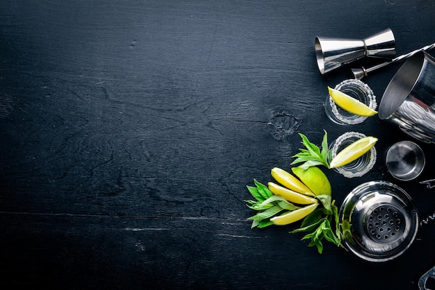 Tequila with lime and ice on a black wooden surface Top view Free space