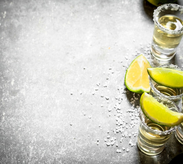 Tequila with lime and salt. On the stone table.