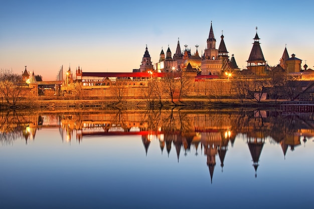 Teremki of the Izmailovsky Kremlin in Moscow with reflection in the water of the pond in the light of evening lights