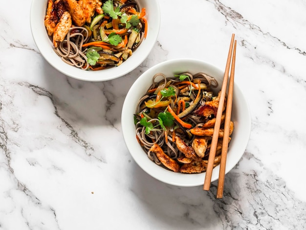 Teriyaki chicken stir fry seasonal autumn vegetables with soba noodles on a light background top view