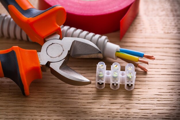 Terminal blocks for electric cables nippers insulating tape on wooden board