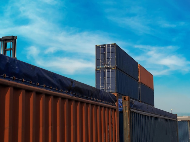 Terminal warehouse mortgage cargo container orange blue color\
forklift crane trade engineer technology transportation company\
factory logistic ecommerce international import exportsunset\
evening sky