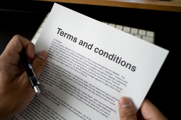 Photo terms and conditions businessman reviewing  terms and conditions of agreement office terms and conditions