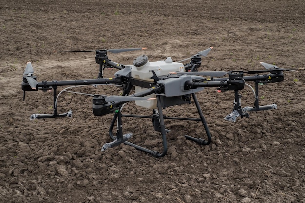 TERNOPIL REGIO OEKRAÏNE 06 mei 2023 Nieuwe drone-spuitmachine DJI AGRAS T30 op de achtergrond van een geploegd veld, uitpakken van precisielandbouw de nieuwste landbouw