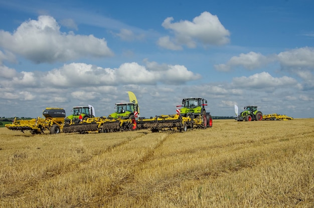 TERNOPIL REGION, UKRAINE - AUGUST 10, 2021: Claas 950 axion tractors with Bednar harrows at the demonstration of agricultural machinery at the exhibition of the company "Lan"