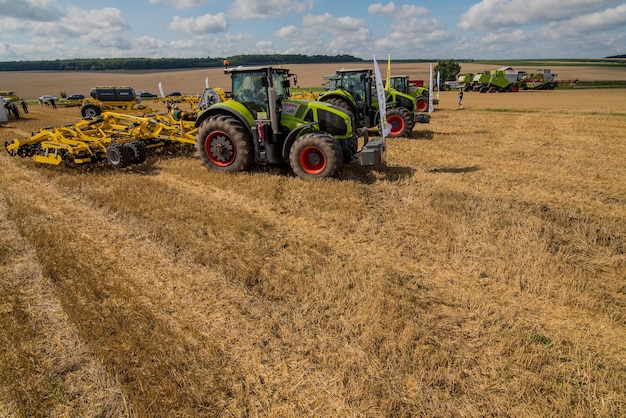 TERNOPIL REGION, UKRAINE - August 10, 2021: tractors CLAAS 950 Axion with trailed harrows Bednar at the demonstration of agricultural machinery, exhibition of the company "Lan"