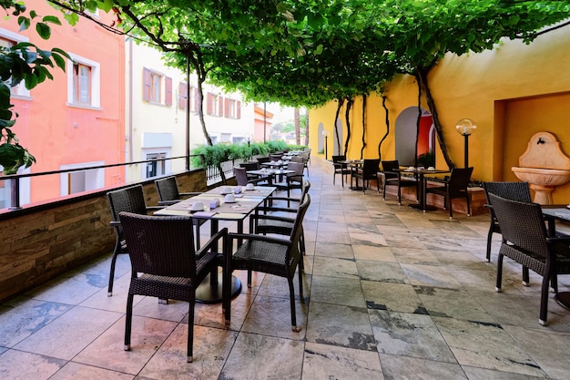 Terrace and Hotel breakfast restaurant interior on background. Empty architecture white room. Veranda of Bar with tables and chairs. Light Vintage style. Morning design. Cafe menu. Lunch, dinner