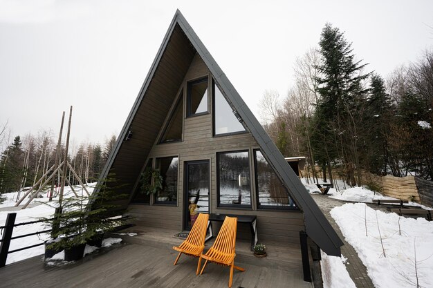 Terrace of wooden triangle country tiny cabin house in mountains and two chairs