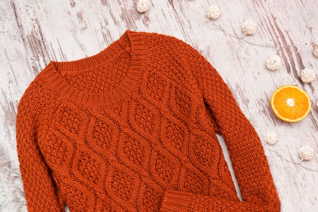 Terracotta sweater on a wooden surface