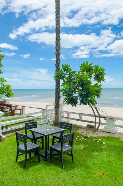 Terras met uitzicht op zee met houten tuinstoelen en een tafel