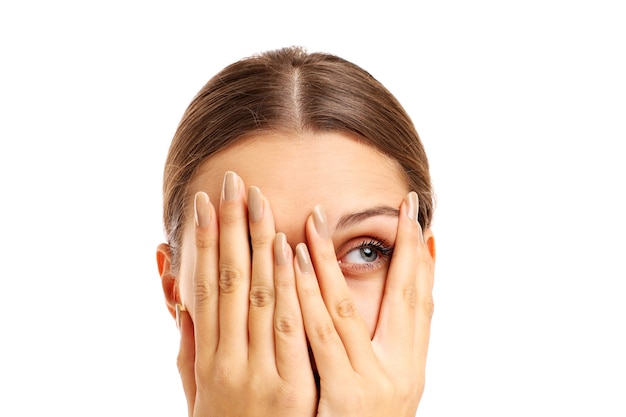 terrified woman covering her face on white background