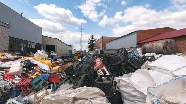 On the territory of the recycling plant. Against the blue sky, heaps of plastic debris lie