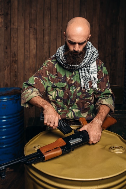 Il terrorista inserisce la rivista nel fucile kalashnikov