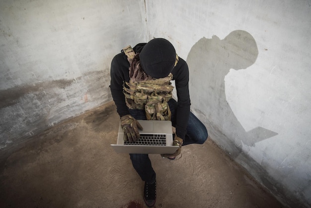 テロリストの男サイバーハッカーがインターネットにアクセスして情報を盗む