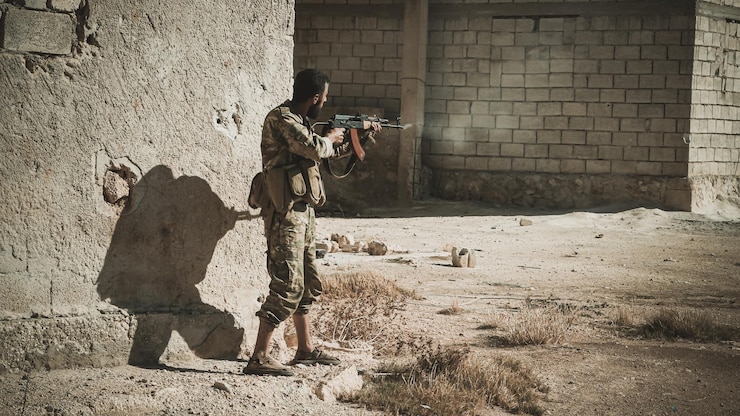 Foto terrorist met geweer terwijl hij bij het gebouw staat.